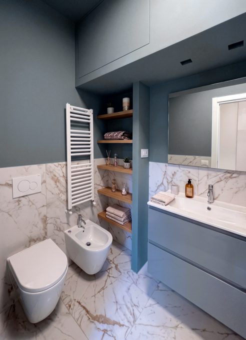 Bagno contemporaneo con finiture in gres effetto marmo e pareti blu polvere
