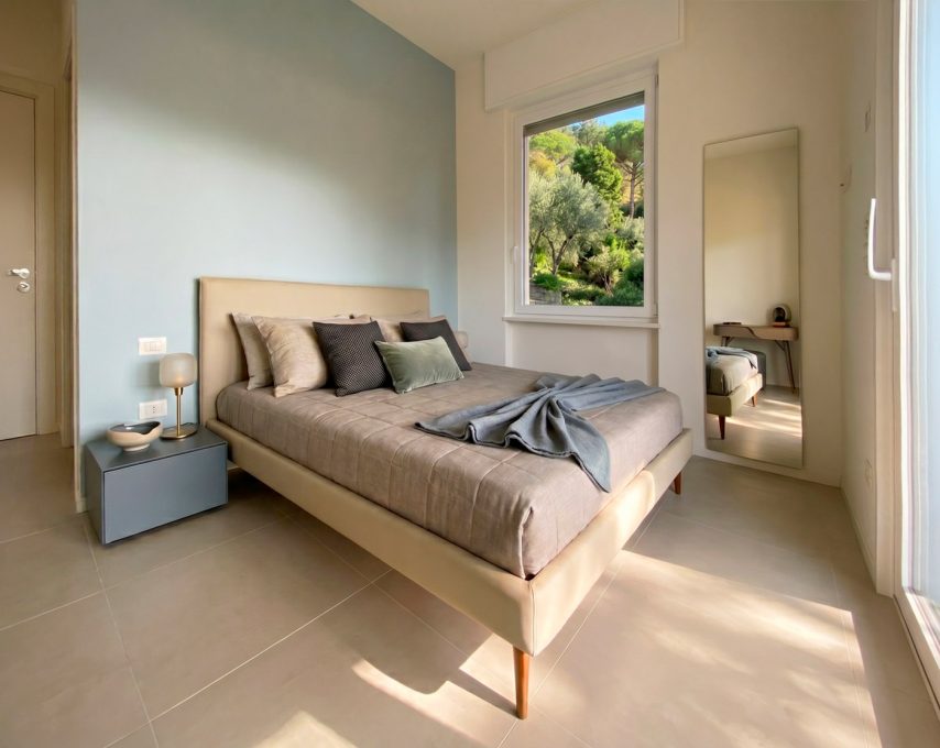 Camera da letto contemporanea con parete azzurro polvere e vista giardino